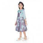 Young girl wearing a blue floral fit and flare dress with a matching 3/4 sleeve shrug and stylish flats