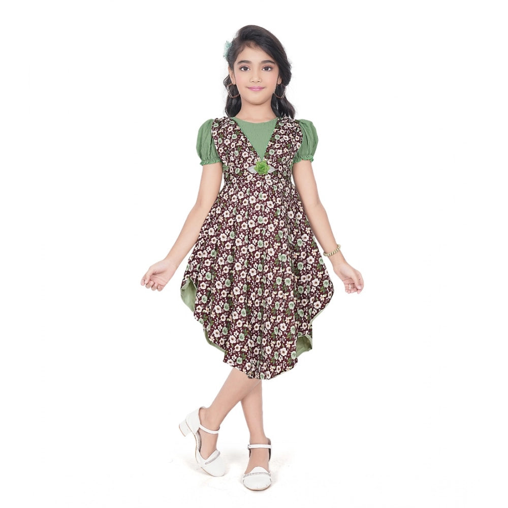 Young girl wearing a green floral layered asymmetrical dress with puff sleeves and stylish white flats