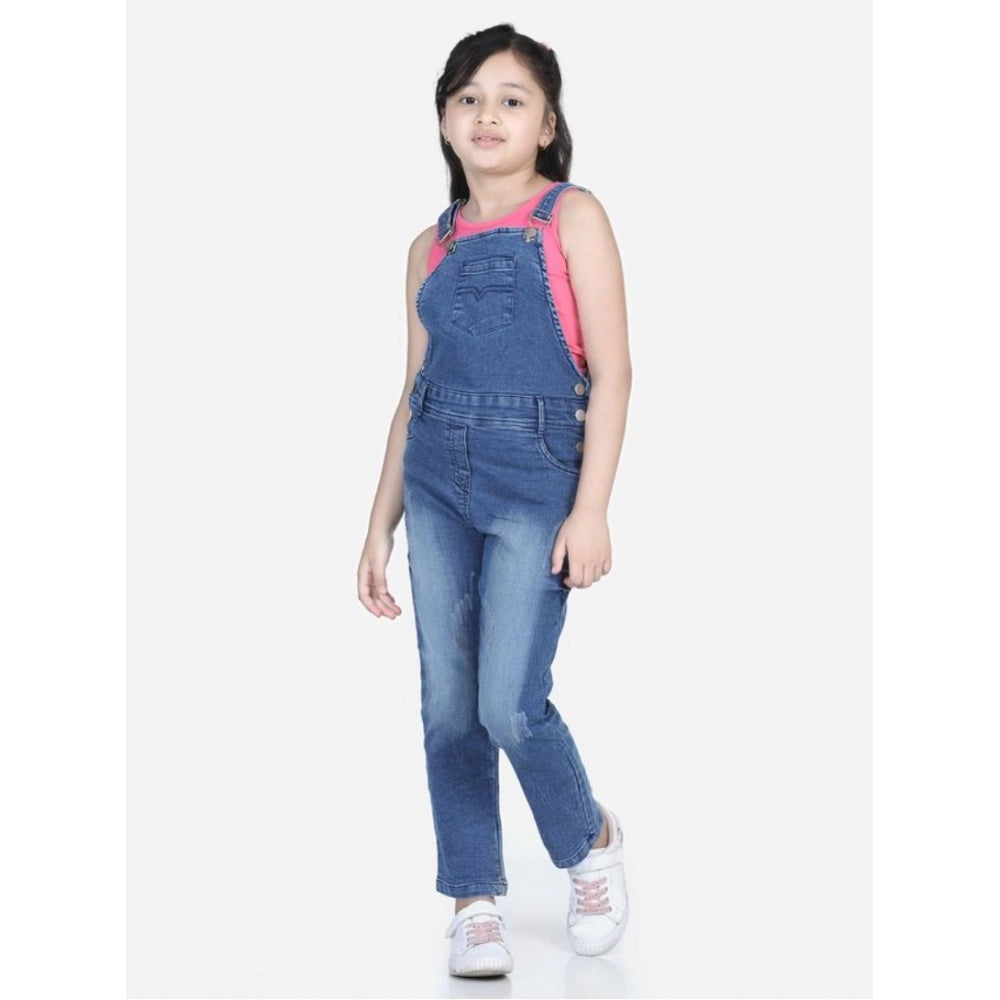 Young girl wearing a blue denim dungaree jumpsuit with pink sleeveless top