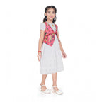 Young girl wearing a premium white eyelet dress layered with a vibrant strawberry print vest, perfect for festive or party wear